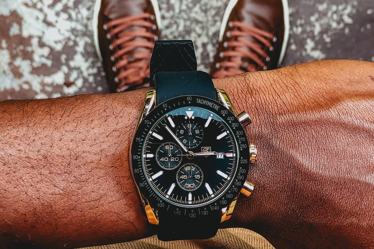 A close-up of a man checking his Breitling watch, featuring multiple complications including a chronograph.