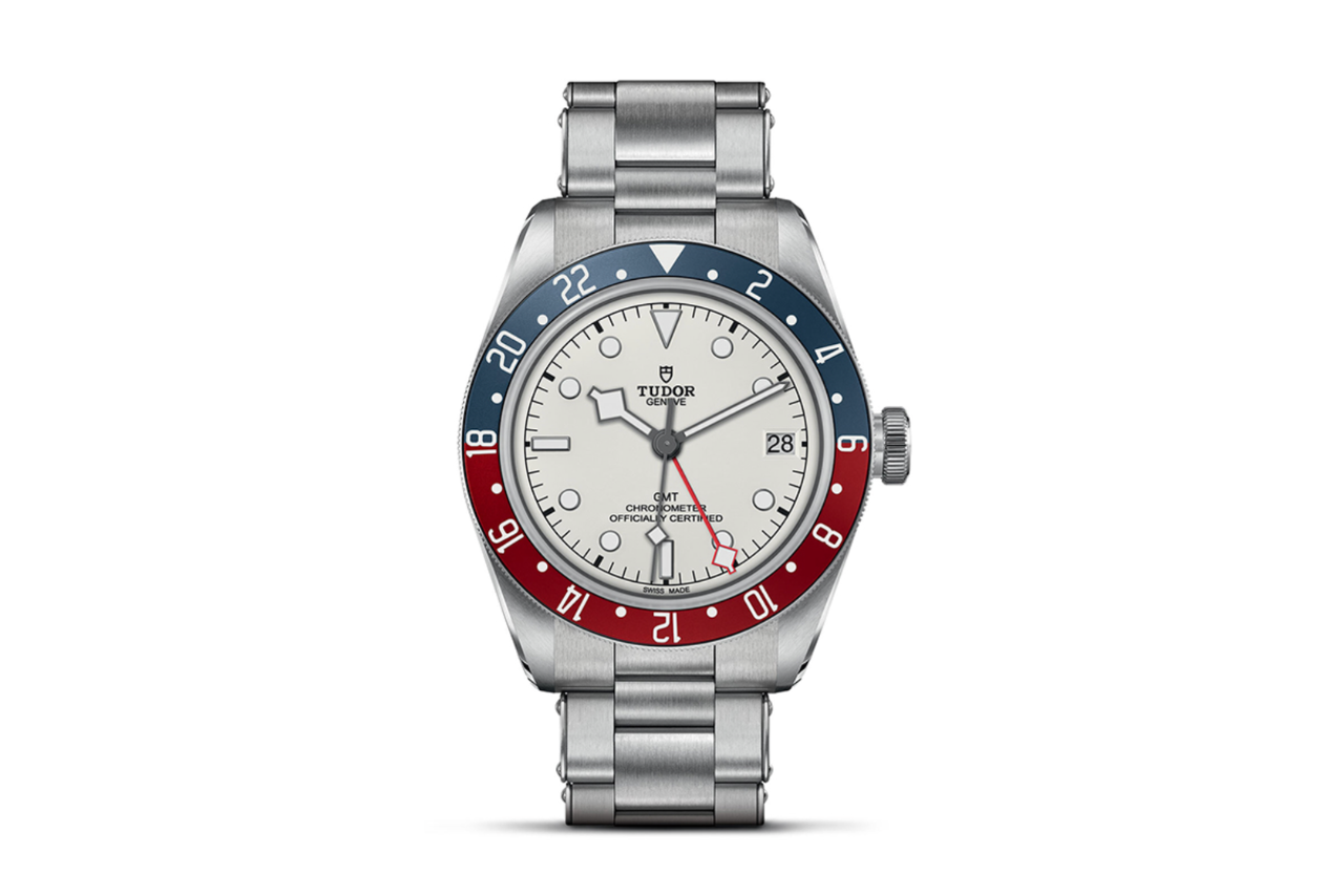 A TUDOR Black Bay silver watch with a half red, half blue bezel and a white watchface.