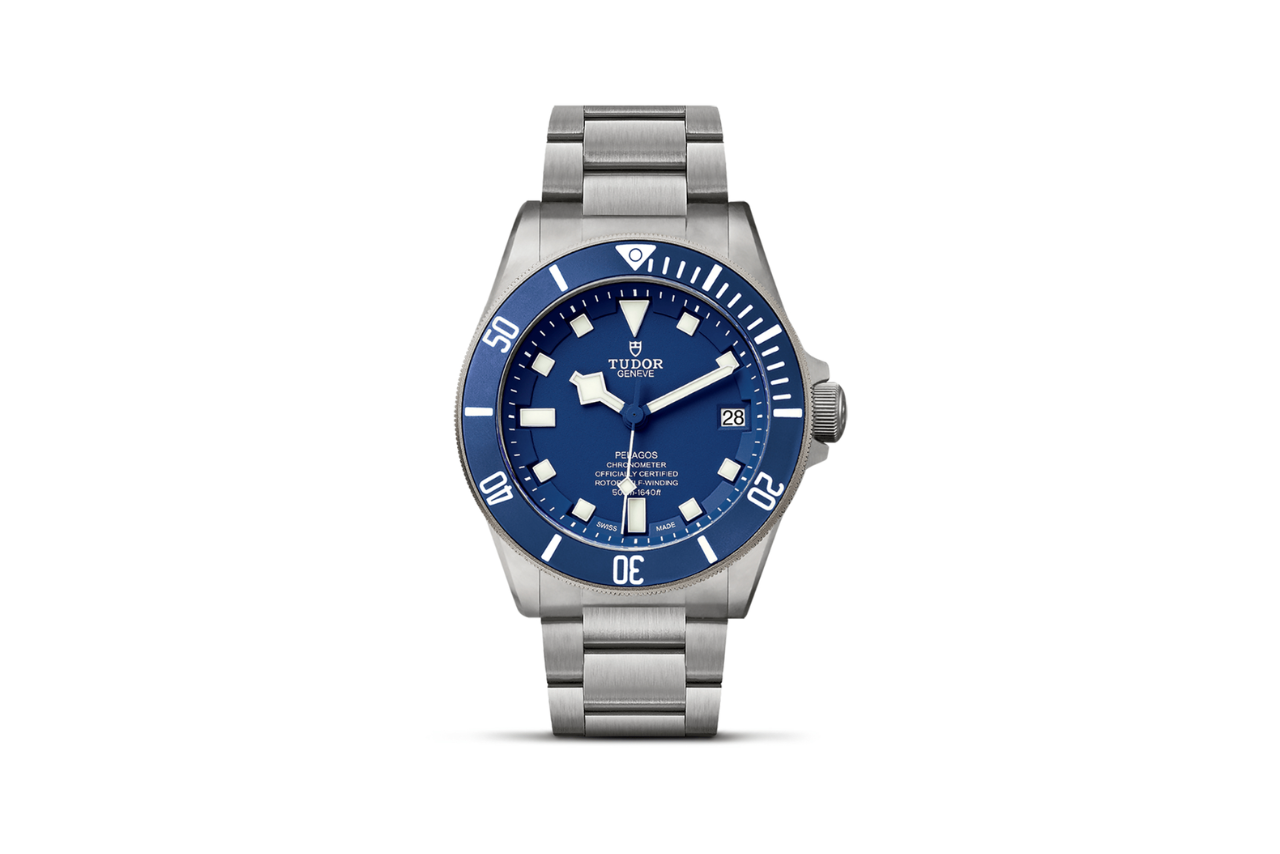 A TUDOR Pelagos silver watch with a navy blue bezel and a watchface to match.