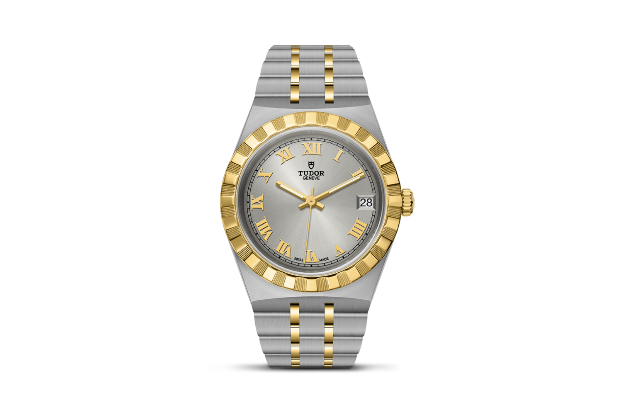 A TUDOR Royal silver watch with a golden bezel and golden accents on the silver watchface.