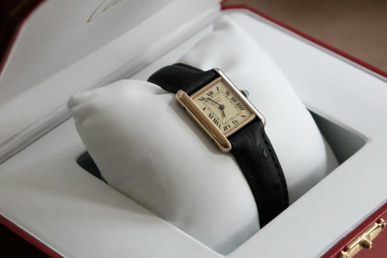 A close up of a Cartier leather wristwatch in a white jewelry box