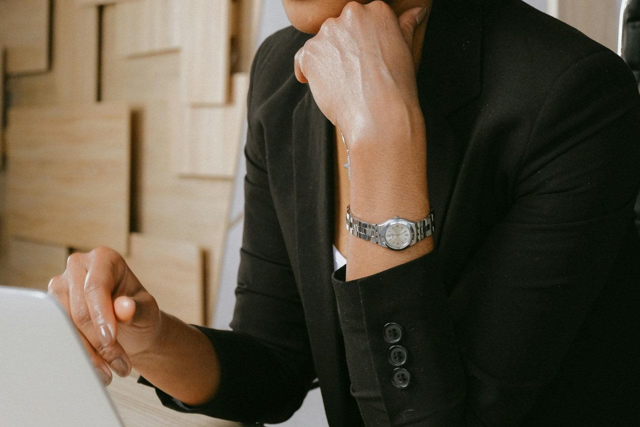 a woman in a black top wearing a silver toned watch with a small dial