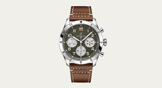 a vintage-inspired Breitling watch with a dark neutral dial and a brown strap