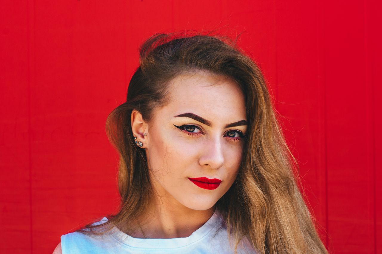 A trendy young woman wearing multiple stud earrings in one ear. A trendy young woman wearing multiple stud earrings in one ear.