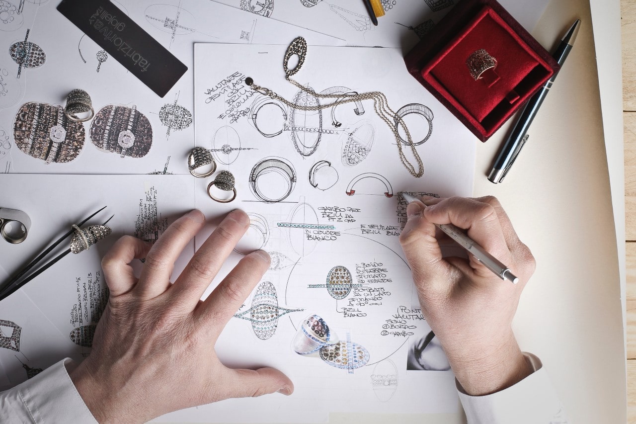 a designer sketching custom jewelry designs