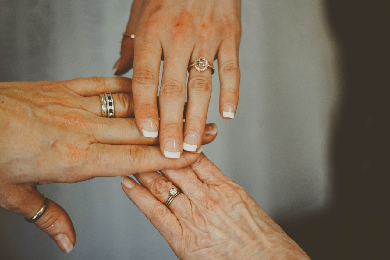 Three generations of hands yellow and rose gold wearing rings, symbolizing love and family connections Three generations of hands yellow and rose gold wearing rings, symbolizing love and family connections
